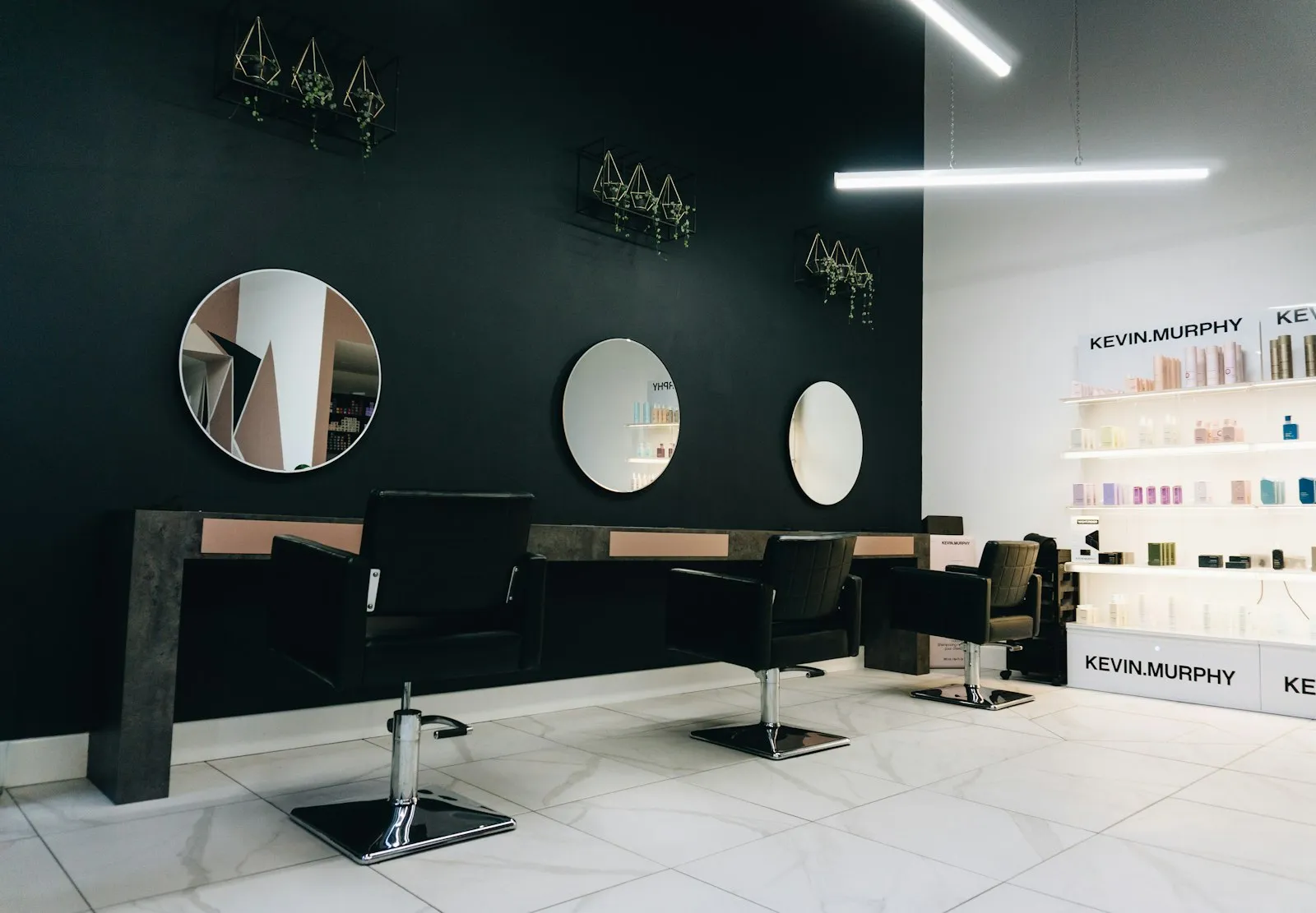 Nowoczesne wnętrze salonu fryzjerskiego Aurora Hair Studio — stanowiska stylizacyjne z okrągłymi lustrami